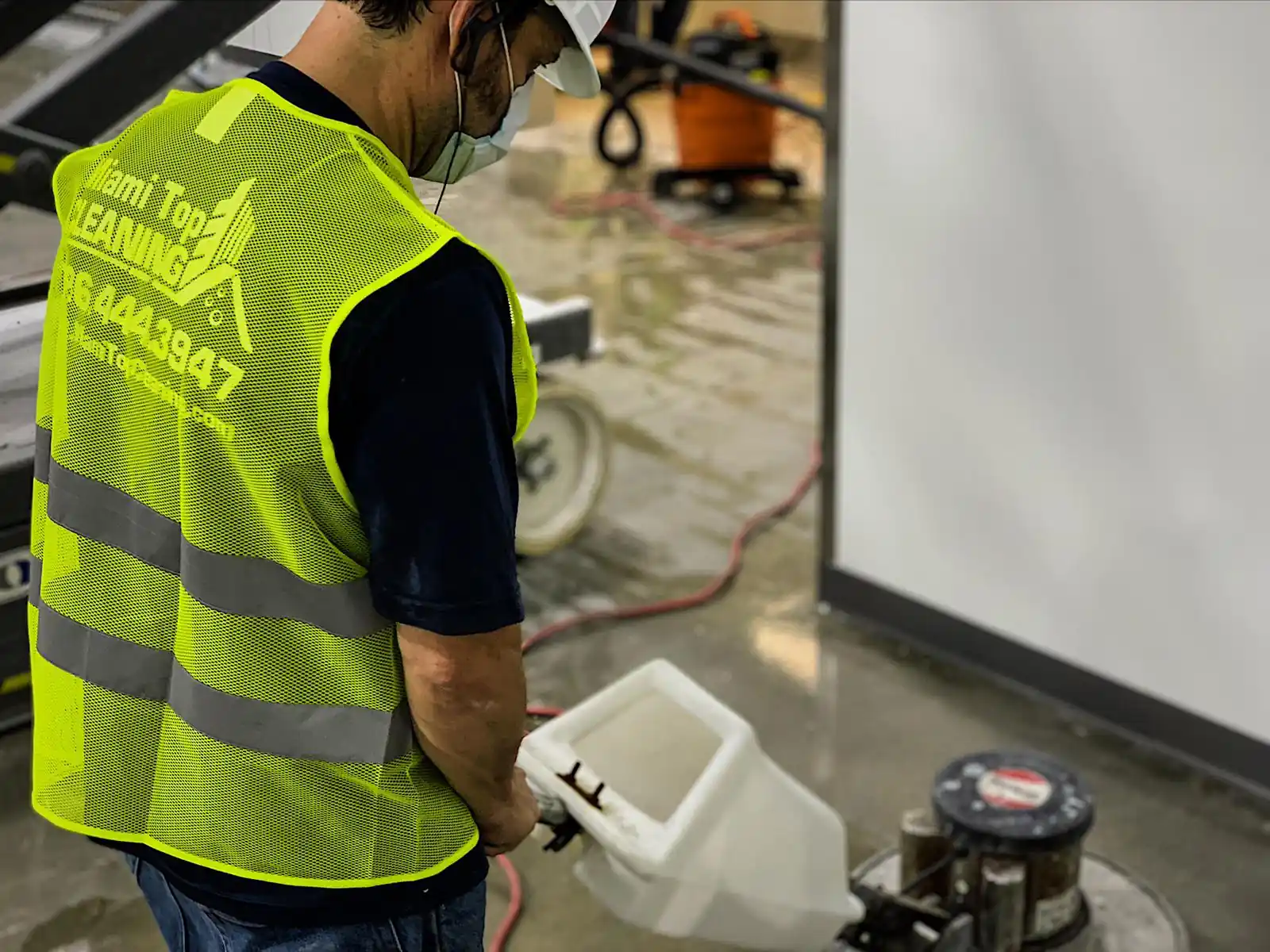 Technician scrubbing off old floor finish with a floor machine during a commercial strip and wax