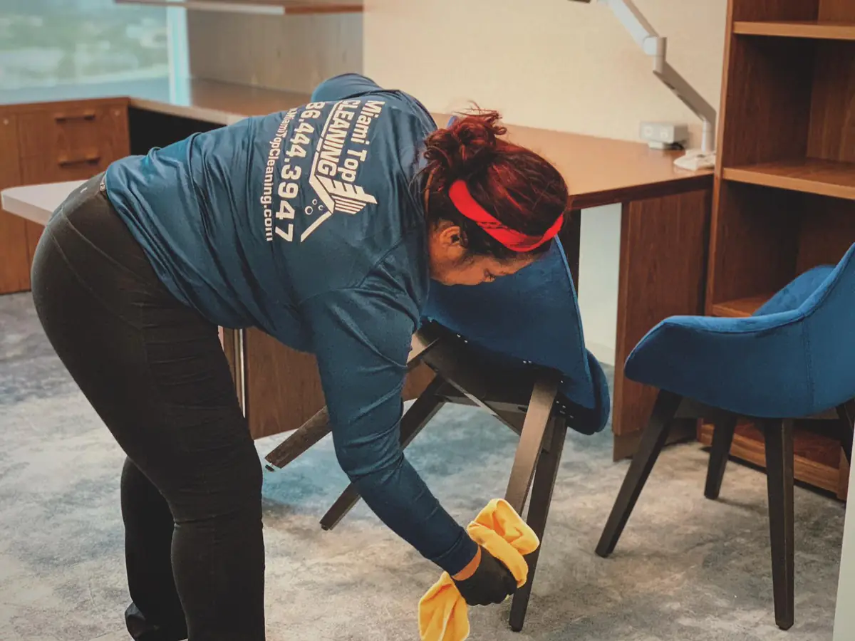 Miami Top Cleaning employee cleaning a carpeted commercial office